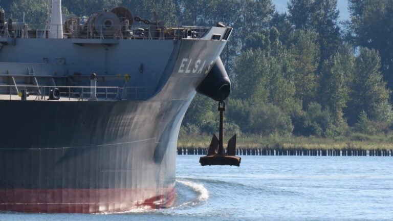 An anchor partly deployed, hanging out of the hawse pipe